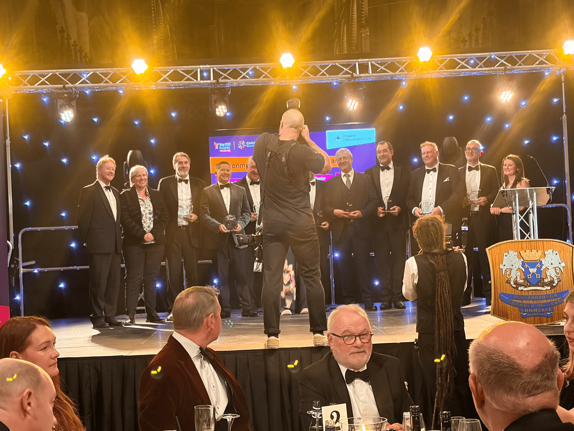 Award winners posed on stage while a photographer takes their picture