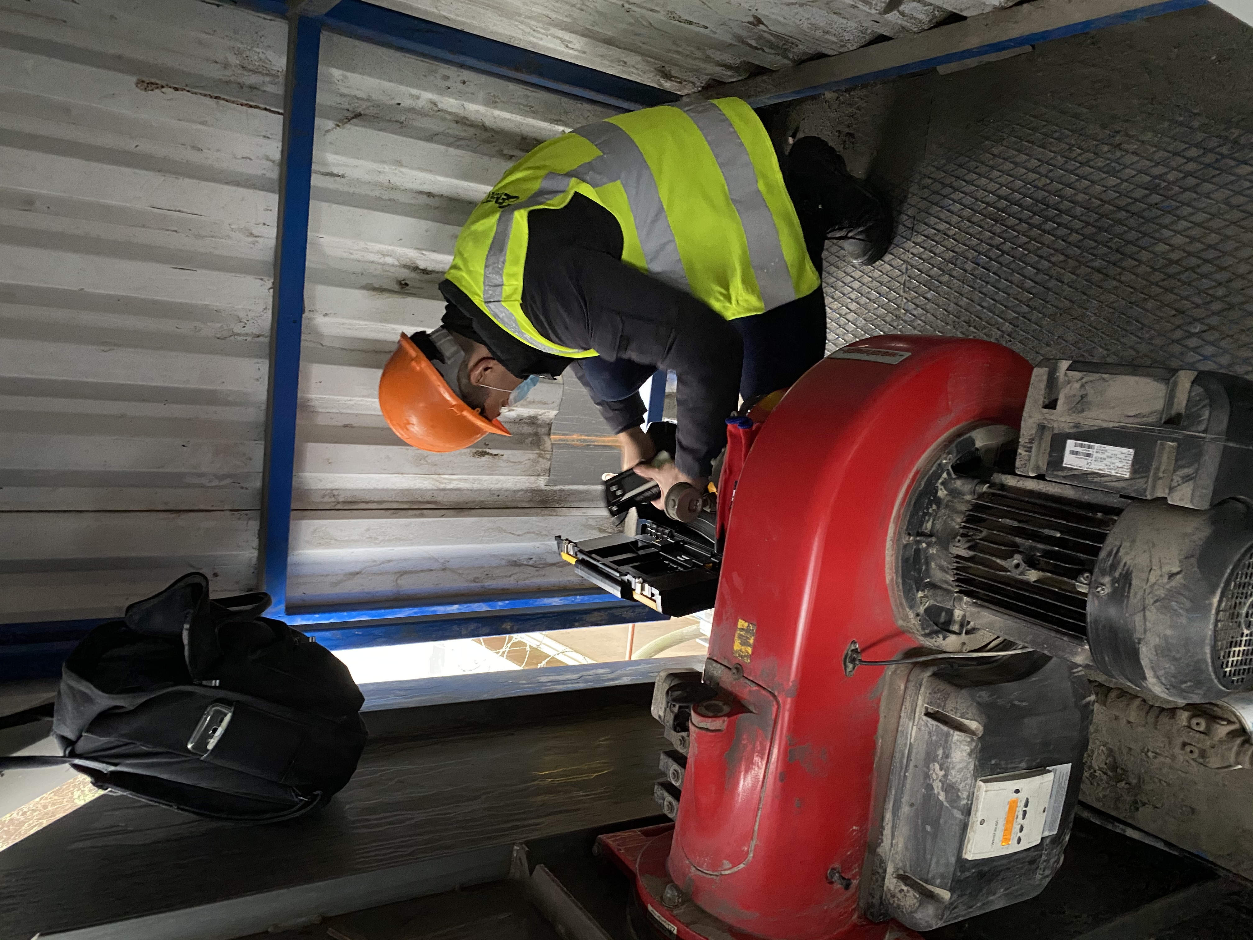 TYPE: photograph
CONTENT: A person wearing an orange hard hat, face mask, and high-visibility vest is performing
