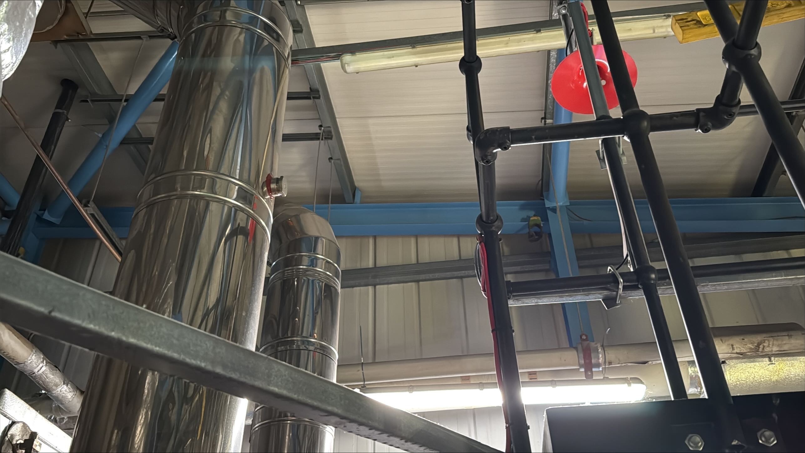 TYPE: photograph
CONTENT: This image depicts an industrial or factory interior, showcasing a network of pipes,